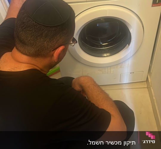 אדם בודק מכונת כביסה טלפונקן